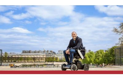 Mango Mobility - Blog over Whill C2 - man kijkt blij naar de camera terwijl hij in zijn elektrische rolstoel zit